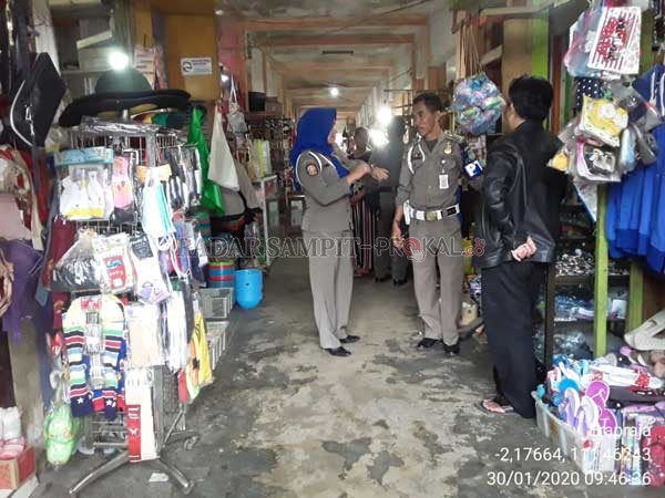 RAZIA ; Anggota Satpol PP Lamandau saat memantau salah satu pasar di Kota Nanga Bulik guna merazia ASN.(RIA MEKAR/RADAR PANGKALAN BUN)