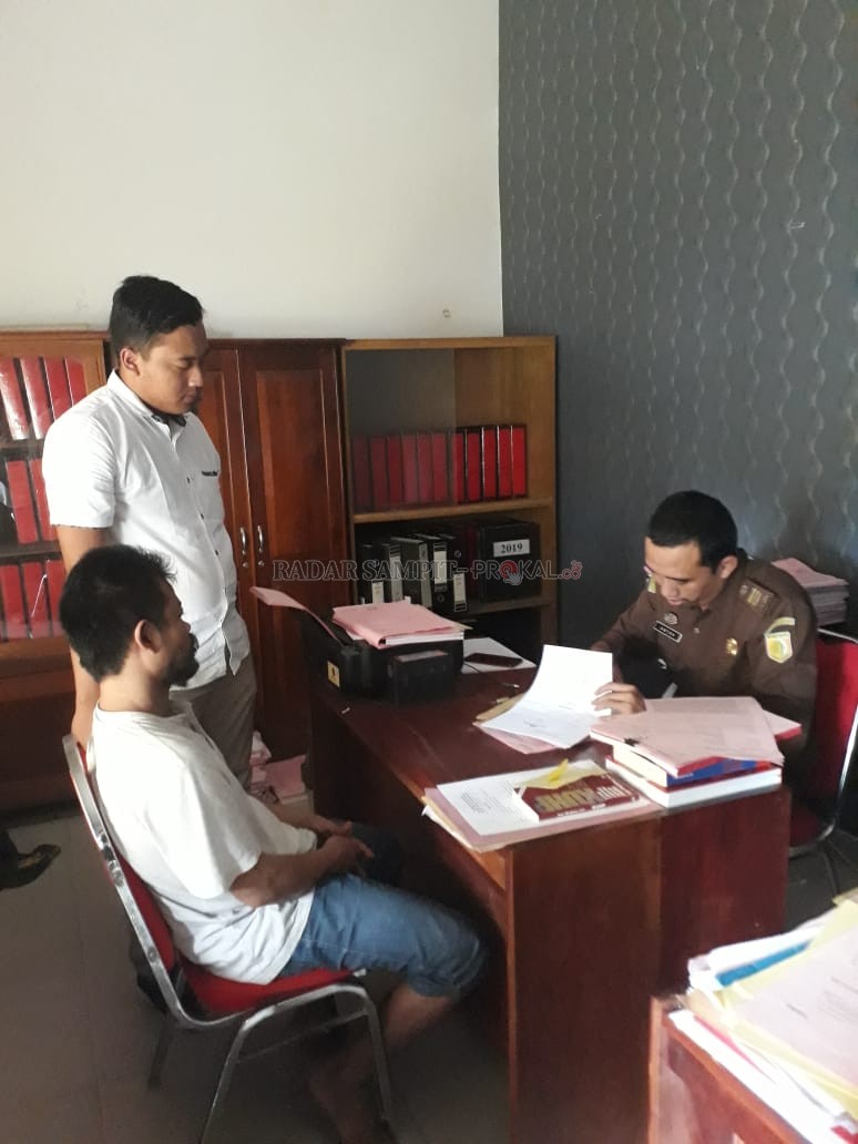 MENUNGGU JADWAL SIDANG : Anggota Polsek Pangkalan Banteng (berdiri) saat penyerahan tahap II kasus pencurian ban yang dilakukan Yono (duduk) di Kejaksaan Negeri Kobar, Senin (3/2). (SLAMET HARMOKO/RADAR PANGKALAN BUN)