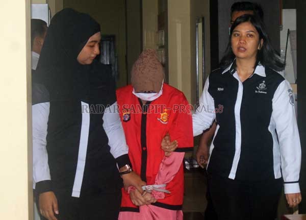 PRAKTIK KECANTIKAN ILEGAL : HN digiring petugas. (Insert) Wadir Krimus Polda Kalteng AKBP Teguh Widodo memperlihatkan barang bukti.(DODI/RADAR PALANGKA)