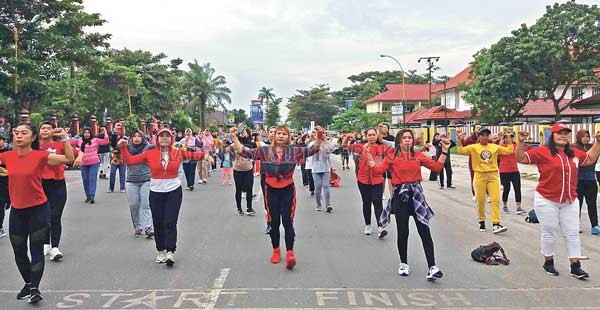 HIDUP SEHAT: Warga Kota Sampit mengikuti gerakan instruktur di atas panggung dalam senam sehat Radar Sampit, Minggu pagi (9/2). Para pemenang doorprize yang dibagikan sehabis acara.(TONO/RADAR SAMPIT)