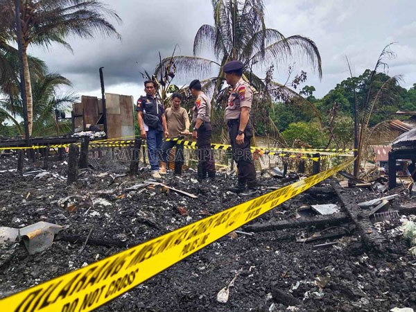 PUING SISA KEBAKARAN : Kapolsek Murung Ipda Yuliantho (dua dari kanan) bersama anggotanya mengecek lokasi kebakaran di Desa Muara Sumpoi, Kecamatan Murung, Kabupaten Mura. RENO/RADAR SAMPIT