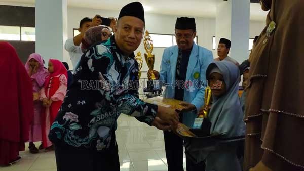 PIALA: Asisten I Setda Kotim Nur aswan saat menyerahkan piala kepada peserta pemenang lomba rangkaian kegiatan Festival Anak Salah Indonesia (FASI) ke- 13  tingkat Kabupaten Kotawaringin Timur (Kotim), Minggu (23/2).(YUNI/RADAR SAMPIT)