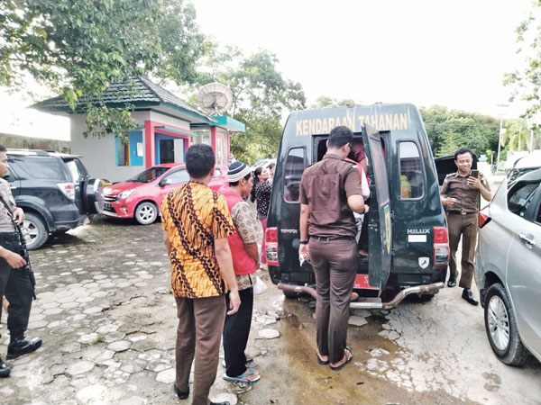 TERDAKWA: Tukiman (rompi merah) terdakwa kasus karhutla sesaat sebelum masuk ke mobil tahanan, Rabu (26/2) lalu.(RIA MEKAR/RADAR SAMPIT)