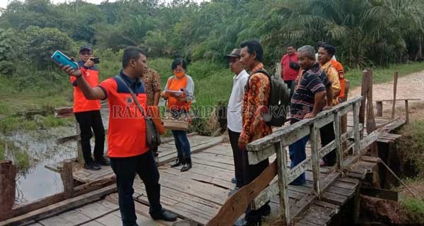 BUTUH PERBAIKAN ; Tim BNPB tinjau jembatan di Desa Sungai Melawen, Kecamatan Pangkalan Lada untuk verifikasi pengajuan bantuan perbaikan.(BPBD KOBAR/RADAR PANGKALAN BUN)