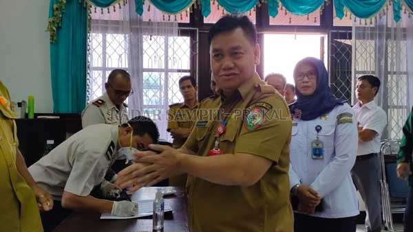 KEBERSIHAN: Sekretaris Daerah (Sekda) Kotim Halikinnor sedang menggunakan cairan pembersih berbasis alkohol (hand sanitizer), sebelum menggelar rapat koordinasi di Lantai II Setda, Senin (16/3).(YUNI/RADAR SAMPIT)