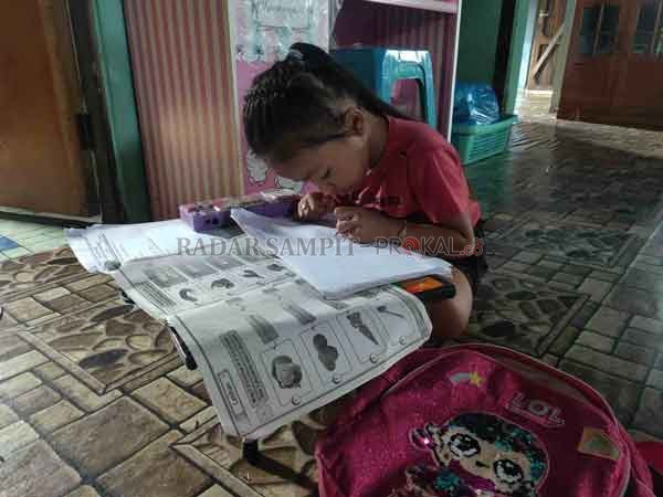 BELAJAR: Salah seorang anak yang tengah belajar di rumah.(DIAN TARESA/RADAR SAMPIT)