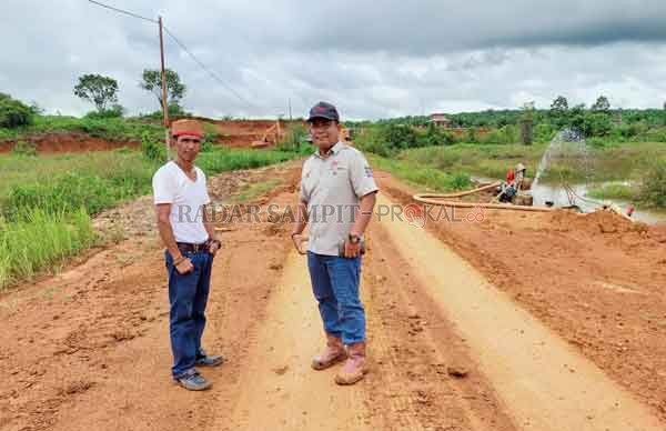TINGKATKAN EKONOMI ; Ketua Kelompok Tani, M. Darsani bersama KTU PT BJAP 1 Tumpang Susanto saat melihat jalan dan lokasi pembangunan kolam ikan.(ISTIMEWA/RADAR PANGKALAN BUN)