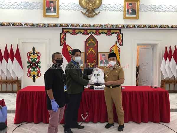 BERI BANTUAN : Gubernur Kalteng Sugianto Sabran (kanan) menyerahkan bantuan masker untuk wartawan yang diterima oleh Ketua PWI Kalteng Haris Sadikin (kiri). (YUSHO/RADAR PALANGKA)