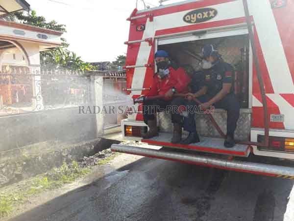 SEMANGAT: Petugas Satgas Covid-19 sedang menyemprotkan disinfektan di ruas jalan protokol Kota Palangka Raya.(HUMAS/RADAR PALANGKA)