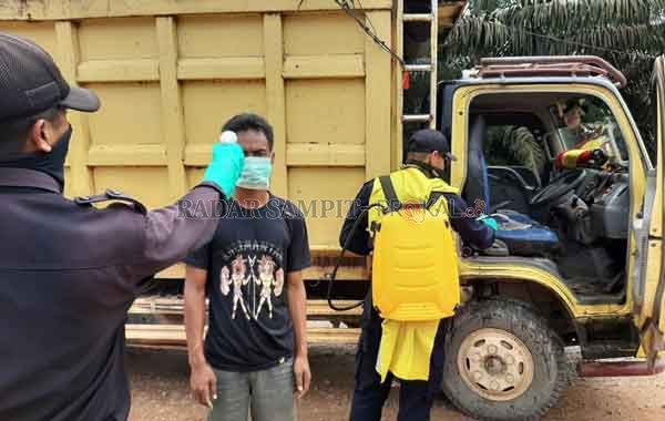 CEGAH COVID-19 : Petugas keamanan PT. SSS lakukan pengecakan suhu tubuh kepada sopir pengangkut sawit yang akan masuk ke lingkungan perusahaan. Selain itu mereka juga melakukan penyemprotan disinfektan pada kendaraan dari luar wilayah mereka.( ISTIMEWA/RA