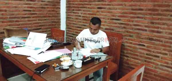 PEKERJAAN: Ketua DPRD Seruyan Zuli Eko Prasetyo saat sedang menandatangani sejumlah dokumen, dan tetap melaksanakan pekerjaan meskipun sedang berada di rumah.(IST/RADARSAMPIT)