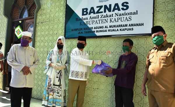 PENYERAHAN - Bupati Kapuas Ir. Ben Brahim S Bahat, MM. MT dan Ibu Ary Egahni melalui Badan Amil Zakat Nasional (BAZNAS) memberikan bantuan berupa sembako sebanyak 400 paket di halaman Masjid Agung Al-Mukaram, selasa (21/4/2020).