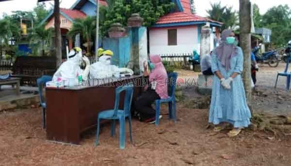 PEMERIKSAAN: Sejumlah warga Desa Wonorejo, Kecamatan Sematu Jaya, Kabupaten Lamandau saat antre menjalani rapid test,  setelah melapor melakukan kontak langsung dengan keluarga pasien Positif Covid-19.(RIA MEKAR/RADAR PANGKALAN BUN)