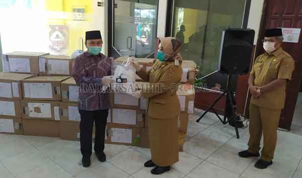 BANTUAN: Gubernur Kalteng Sugianto Sabran menyerahkan bantuan masker kepada Bupati Kobar Hj Nurhidayah, Senin (27/4).(RINDUWAN/ RADAR PANGKALAN BUN )