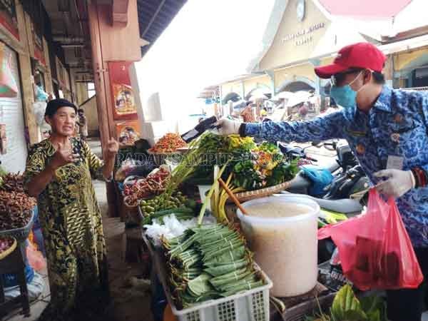 SERAHKAN: Bupati Kotim Supian Hadi menyerahkan masker kain kepada pedagang yang ada di kawan PPM, belum lama ini.(DESIWULANDARI/RADARSAMPIT)