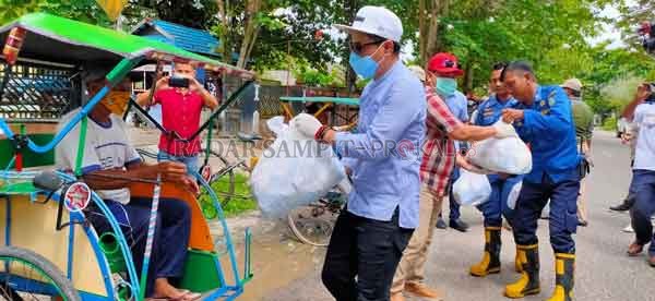 TURUN TANGAN: Bupati Kotim Supian Hadi ikut turun membantu membagikan bahan kebutuhan pokok.(YUNI PRATIWI/RADAR SAMPIT)