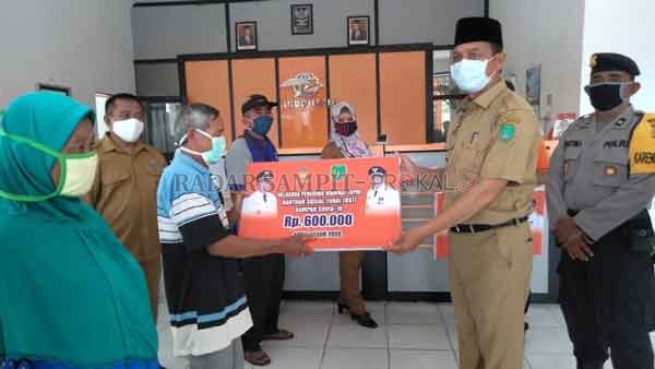 BANTUAN: Bupati Sukamara menyerahkan bantuan sosial tunai kepada warga.