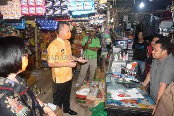 MENGECEK : Bupati Gumas Jaya S Monong didampingi Wakil Bupati Efrensia LP Umbing langsung turun ke lapangan untuk mengecek ketersediaan pangan berupa sembako, di Pasar Tradisional Kuala Kurun, belum lama ini.(ARHAM SAID/RADAR SAMPIT)