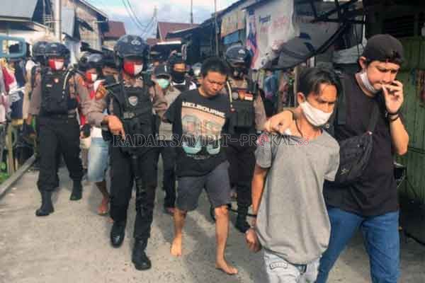 DIAMANKAN : Petugas saat mengamankan pelaku usai dilakukan penggerebekan lokasi penjualan sabu di kawasan Puntun.(DODI RADAR PALANGKA)