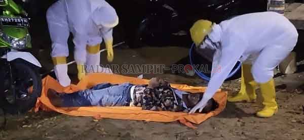 MENDADAK:  Petugas kepolisian saat mengevakuasi jenazah Bambang dari lokasi kejadian di Jalan Trans Kalimantan, Sabtu (30/5) malam.(istimewa)