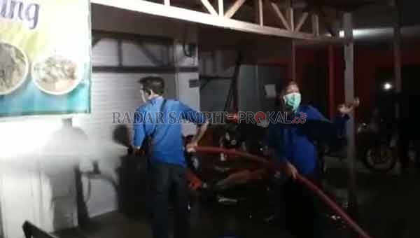 TINDAK TEGAS: Petugas menyemprotkan air di tempat usaha warga yang buka pada malam hari di Kota Kuala Kapuas, Senin (8/6) malam.(ALEXANDER/RADAR SAMPIT)