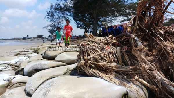 ABRASI: Kondisi Pantai Ujung Pandaran, yang bibir pantainya makin hari makin terkikis akibat abrasi, tumpukan karung pasir tak mampu menahan ombak.(DESIWULANDARI/RADARSAMPIT)