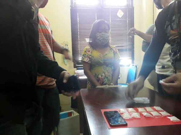 TERSANGKA: Aminah saat diamankan bersama barang bukti 12 paket sabu seberat 60 gram dari kawasan Puntun.(istimewa)