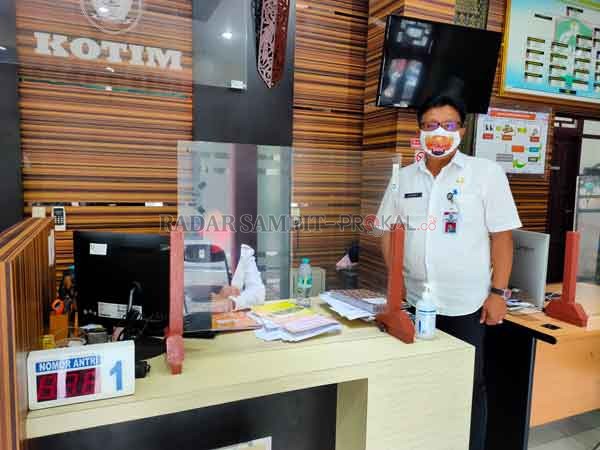 PELAYANAN: Kepala Dinas Penanaman Modal Pelayanan Terpadu Satu Pintu (DPMPTSP) Johny Tangkere saat berada di loket pelayanan, Rabu (24/6).(YUNI/RADAR SAMPIT)