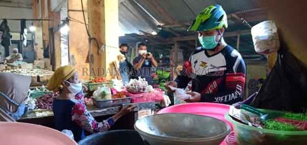 SOSIALISASI: Bupati Lamandau Hendra lesmana saat membagikan masker gratis di pasar tradisional Kabupaten Lamandau, kemarin.(Ria/Radar Sampit)