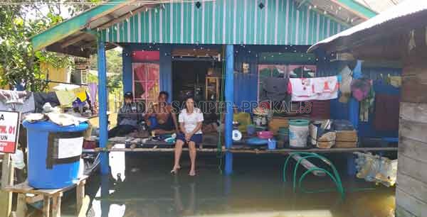 BANJIR: Masyarakat Desa Rungun, Kecamatan Kotawaringin Lama, saat berada di rumah karena akses jalan yang tergenang air.(RINDUWAN/RADAR SAMPIT)