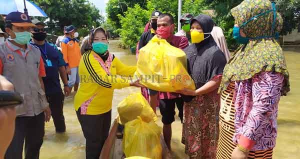 SOSIAL: Bupati Kobar Hj Nurhidayah menyalurkan bantuan kepada korban banjir di Desa Kondang, Kecamatan Kotawaringin Lama, Minggu (5/7).(RINDUWAN /RADAR PANGKALAN BUN )