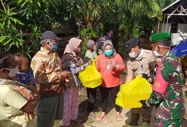 BANTUAN : Bupati Kobar Hj Nurhidayah langsung tanggap dan turun sambil menyalurkan bantuan paket sembako kepada warga yang terdampak banjir di Desa Kumpai Batu Bawah Selasa (7/7).(RINDUWAN /RADAR PANGKALAN BUN )