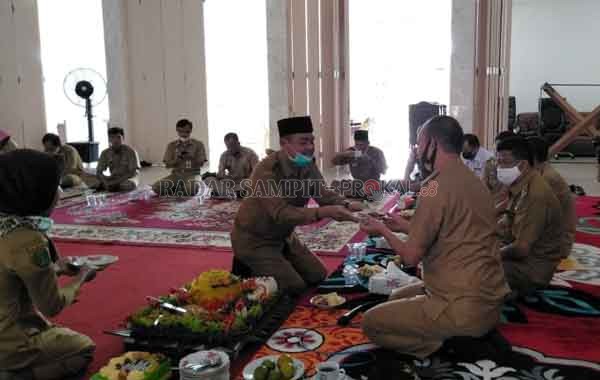 SURPRISE : Bupati Sukamara Windu Subagio menyerahkan potongan nasi tumpeng kepada Sekda Sukamara.(FAUZIANUR/RADAR SAMPIT)