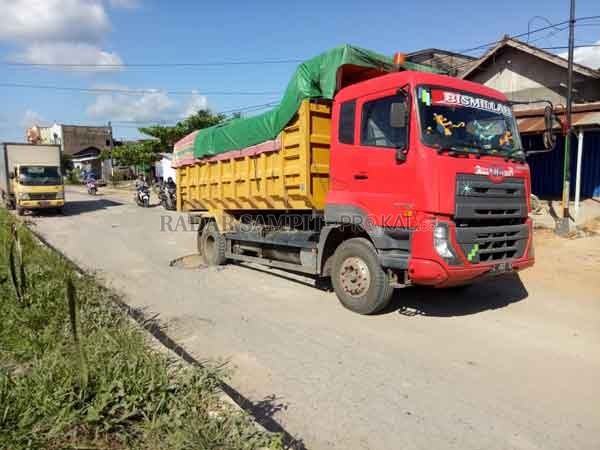 TERSANGKUT: Truk angkutan barang ambles di jalur kilometer  65 Jalan Jenderal Ahmad Yani di Desa Karang Mulya, Kecamatan Pangkalan Banteng.(Slamet Harmoko/Radar Pangkalan Bun)