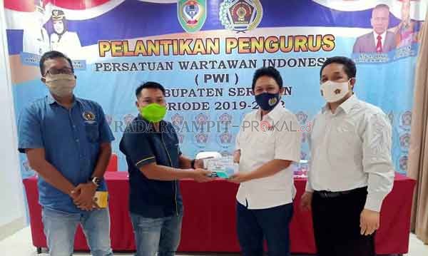 SERAHKAN: Penyerahan masker dan buku kode perilaku wartawan dari PWI Kalteng untuk PWI Kotim.(IST/RADAR SAMPIT)