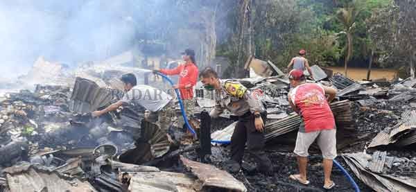 KEBAKARAN : Kapolsek Kapuas Hulu bersama warga saat masih melakukan pemadaman di beberapa rumah yang terbakar.(POLSEK KAPUAS HULU For RADAR SAMPIT)