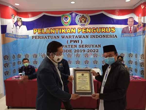 PENGHARGAAN: Bupati Seruyan Yulhaidir (kanan) saat menerima penghargaan dari Persatuan Wartawan Indonesia (PWI) Provinsi Kalimantan Tengah disela-sela pelantikan pengurus PWI Seruyan di aula Grand Hotel Sampit beberapa waktu lalu. (ALDI SETIAWAN/RADAR SAM