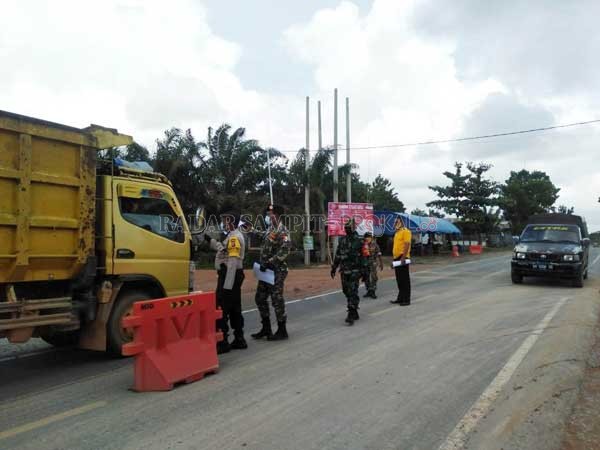 PENGAWASAN ; Sejumlah personil dari lintas sektor saat berjaga di Posko lintas batas antar kabupaten di Desa Amin Jaya, Kecamatan Pangkalan Banteng. Petugas juga mensosialisasikan terkait kewajiban rapid test dan atau PCR bagi para calon penumpang pesawat
