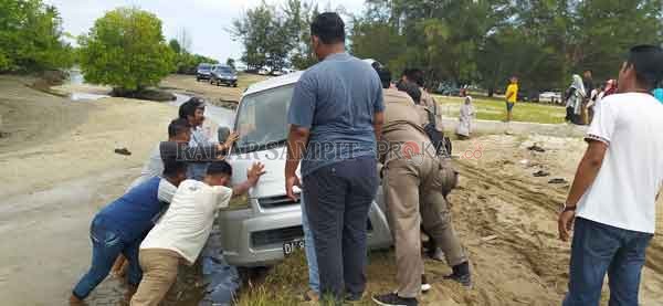 DITOLONG: Satpol PP dan Damkar Kobar saat membantu satu unit mobil yang separuh badan masuk sungai, di Pantai Tanjung Penghujan, Desa Teluk Bogam, Kecamatan Kumai, Kabupaten Kobar, Minggu (2/8).(SULISTYO/RADAR PANGKALAN BUN)