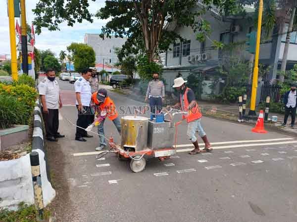 PENUTUPAN : Satlantas Polres Kotim bersama Dishub Kotim, melaksanakan pembuatan marka kejut di simpang pertigaan HM Arsyad - Ahmad Yani, Senin (3/8).(KAPOLRES/RADAR SAMPIT)