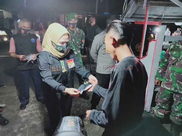PATROLI: Wakil Bupati Seruyan Iswanti saat membagikan masker kepada masyarakat dalam agenda patroli gabungan di wilayah dalam Kota Kuala Pembuang, Sabtu (8/8) malam. (ISTIMEWA/RADAR SAMPIT)