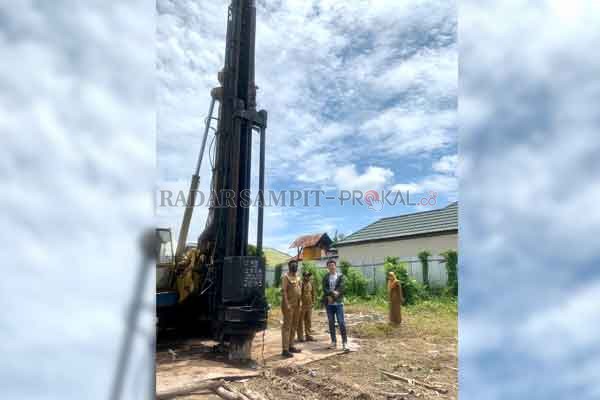 DIHENTIKAN: Kepala DSPMPTSP saat mengecek lokasi pembangunan rumah pribadi yang menuai protes dari warga karena menggunakan alat berat yang membuat rumah warga retak.(RADO/RADAR SAMPIT)