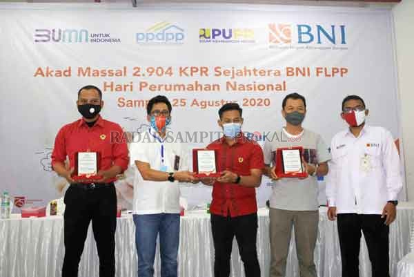HAPERNAS: Pemimpin BNI Cabang Sampit Agung FS Ibat memberikan penghargaan kepada Wengga Febri Dwitananda dari PT Cipta Karya Milenial, Dwi Nurcahya dari PT Citra Mandiri Dwi Pratama, dan PT Budi Jaya Sejahtera Bersama.(HERU/RADAR SAMPIT)