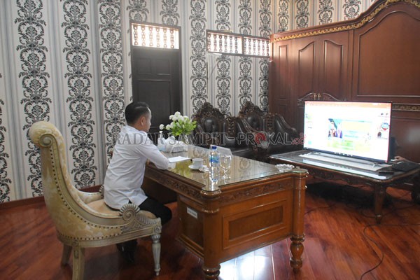 RAPAT : Fairid Naparin mengikuti rapat via daring di rumah jabatan, Rabu (26/8) kemarin.(IST/HUMAS PEMKOT)