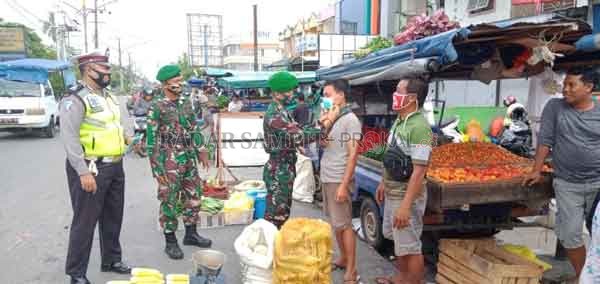 PATROLI: Anggota Kodim 1016 PLK dan Personel Polresta Palangka Raya terpaksa memasangkan masker kepada salah satu pedagang, yang kedapatan tak menerapkan protokol kesehatan di tengah pandemi Covid-19  di Kota Palangka Raya, kemarin.(DODI/RADAR PALANGKA)