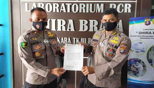 BERSKALA NASIONAL : Kabid Humas Kombes Pol Hendra Rochmawan, Rabu (9/9). Memperlihatkan surat resmi  dengan menyebutkan Laboratorium RS Bhayangkara Tk III, Polda Kalteng sebagai laboratorium pemeriksaan PCR Covid -19 yang berskala nasional.(DODI/RADARPALA