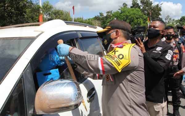 PROTOKOL KESEHATAN: Kapolda Kalteng Irjen Pol  Dedi Prasetyo ketika memasangkan masker kepada salah satu pengguna jalan umum yang kedapatan tidak memakai masket, saat melintas di sekitar Bundaran Besar Palangka Raya, Kamis (10/9) kemarin.(DODI RADAR PALAN