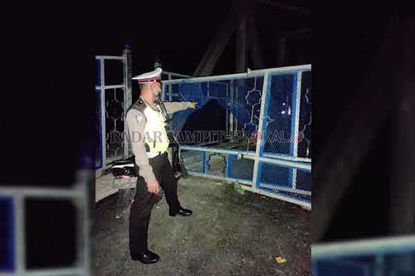 PATROLI : Salah satu anggota kepolisian Polres Batara ketika memperlihatkan kawat pengaman pagar jembatan penyebarangan Muara Teweh-Jingah yang dirusak oleh oknum tak bertanggungjawab, baru-baru tadi.(istimewa)