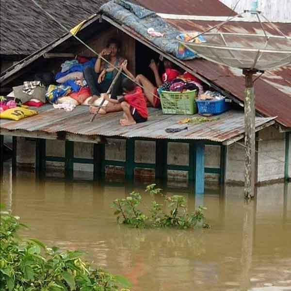 PARAH: Warga yang bermukim di bantaran Sungai Seruyan terpaksa naik ke atap karena rumah terendam banjir.( ALDI/RADAR SAMPIT)