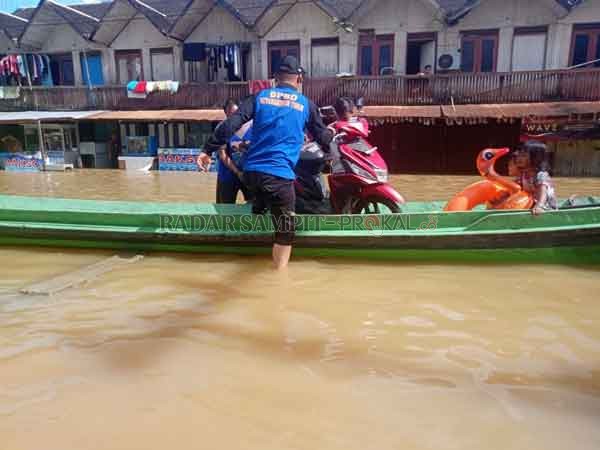 EVAKUASI: Petugas melakukan evakuasi terhadap warga korban banjir di Kuala Kuayan, Kotim. Di Kabupaten Lamandau, banjir sampai menenggelamkan rumah warga di Desa Bayat.